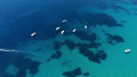 small boats floating over crystal-clear turquoise waters off the coast of albania