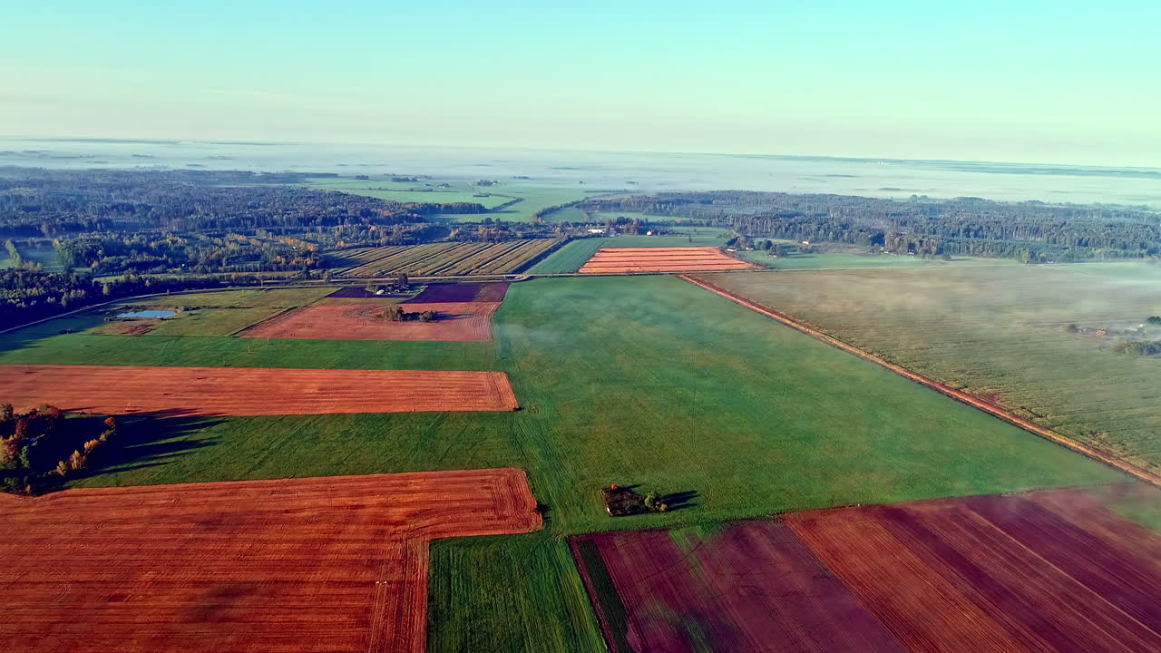 медленный полет самолета над красочными полями посевов в природе солнечным днем на открытом воздухе с голубым небом