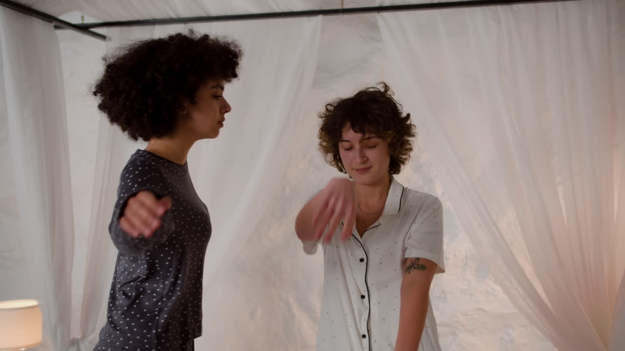 mujeres bailando en la cama