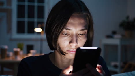 mujer usando el teléfono por la noche