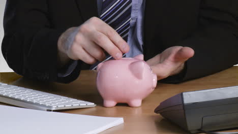 businessman putting money in his piggy bank 2