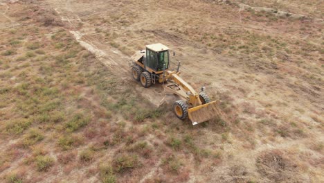 Twin-blade-Motor-Grader-Working-And-Leveling-Field-In-Kyiv,-Ukraine