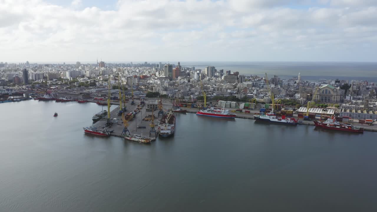 Uruguay capital city Montevideo. Forward moving aerial drone view of barrio Ciudad Vieja, seen from above the port. Calm cloudy weather
