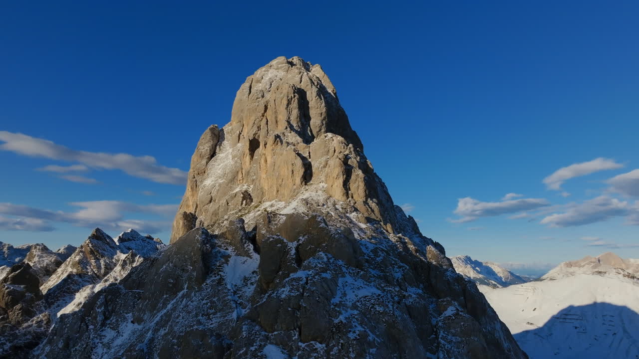 Fast aerial footage flying away from Punta Grohmann Grohmannspitze in the Dolomites in northern Italy in the morning sun.