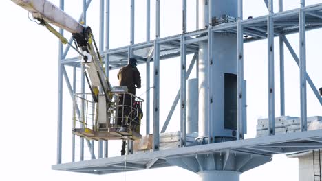 worker cleaning billboard on a scaffold in winter