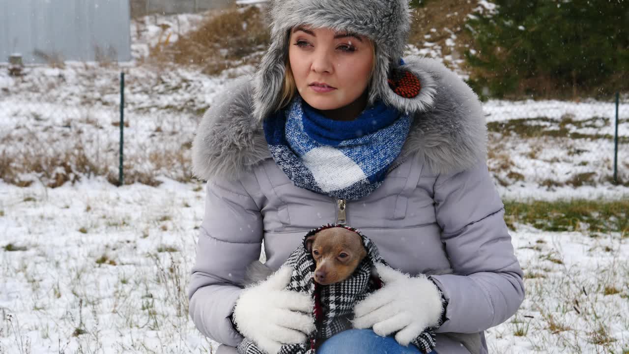 겨울 에 작은 개 를 돌보는 걱정 한 여자