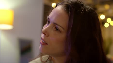 Close-Up-Of-Woman-Sitting-On-Sofa-At-Home-Or-In-Bar-Or-Cafe-Talking-With-Friends