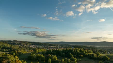 Bewegender-Zeitraffer-Eines-Sonnenuntergangs-über-Bewaldeten-Hügeln-Und-Dörfern