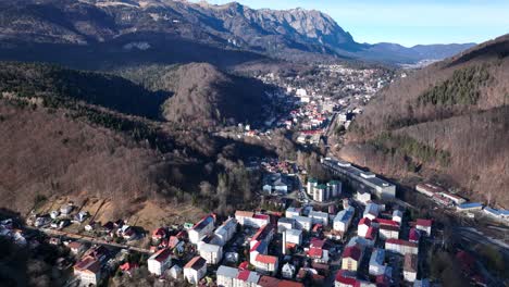 vuelo de drones sobre una pequeña ciudad rumana entre montañas durante el día soleado en la mañana - sinaia, rumania