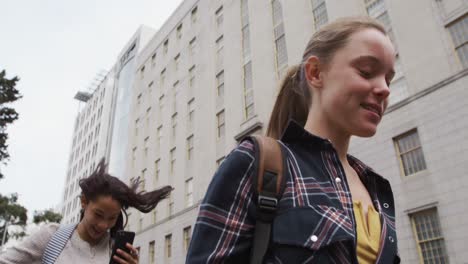 low angle view of a caucasian and mixed race girl hanging out