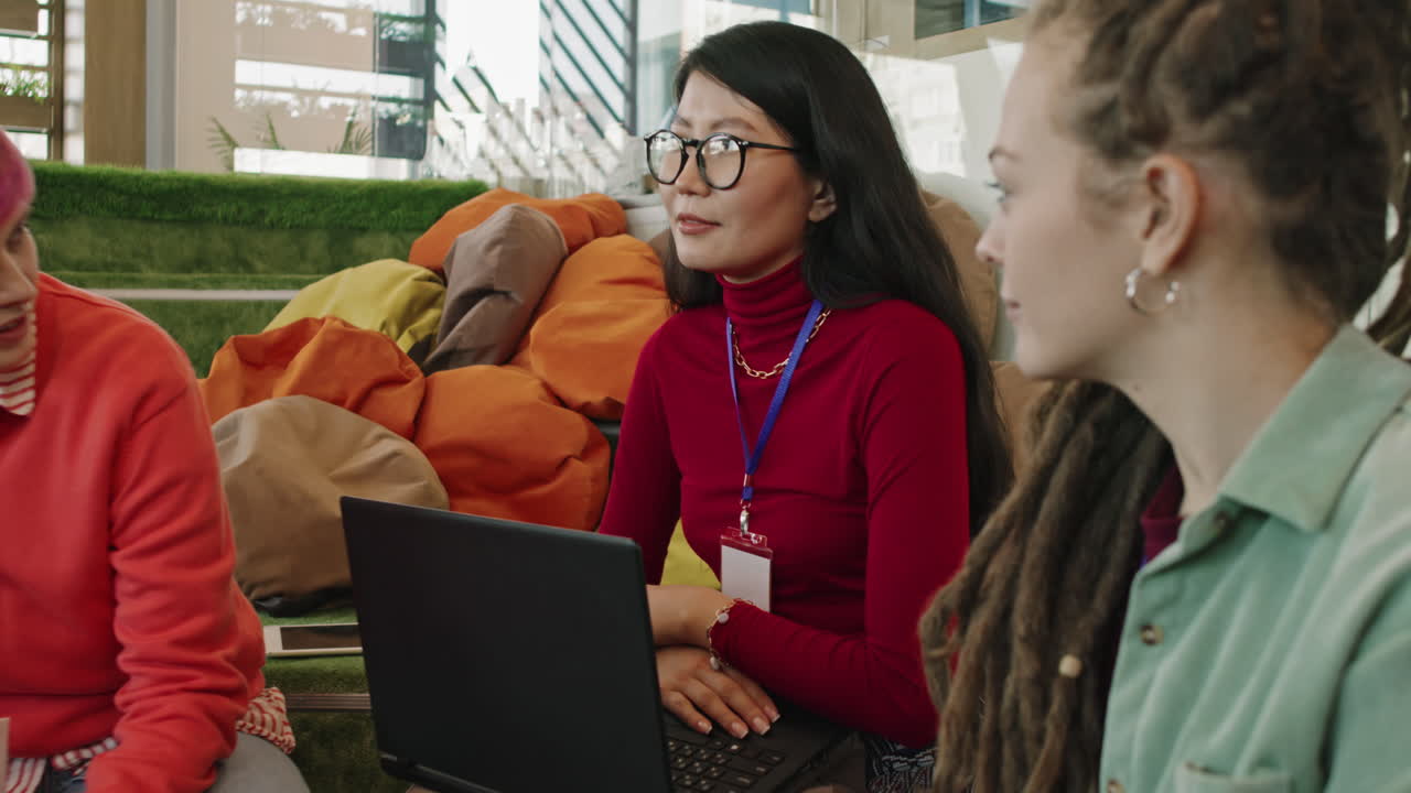 Three Women Discussing Project in Start-Up Office