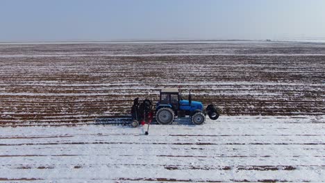 tractor agrícola labrando las tierras de cultivo con nieve en ucrania