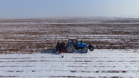 agricultural tractor tilling the farmland with snow in ukraine