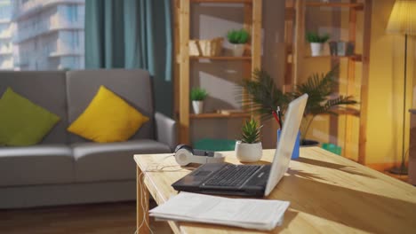 freelancer's workplace at home in the living room on the table laptop headphones documents