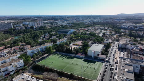 Barrido-Aéreo:-El-Campo-De-Fútbol-De-La-Mosson,-Una-Joya-Verde-En-La-Primavera-Urbana-De-Montpellier