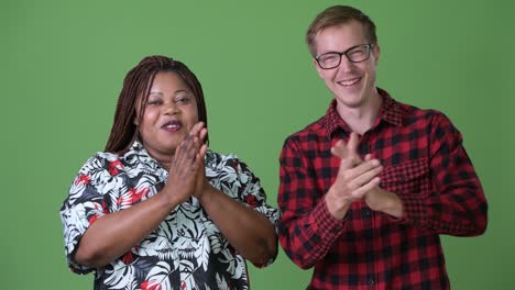 overweight african woman and young scandinavian man together against green background