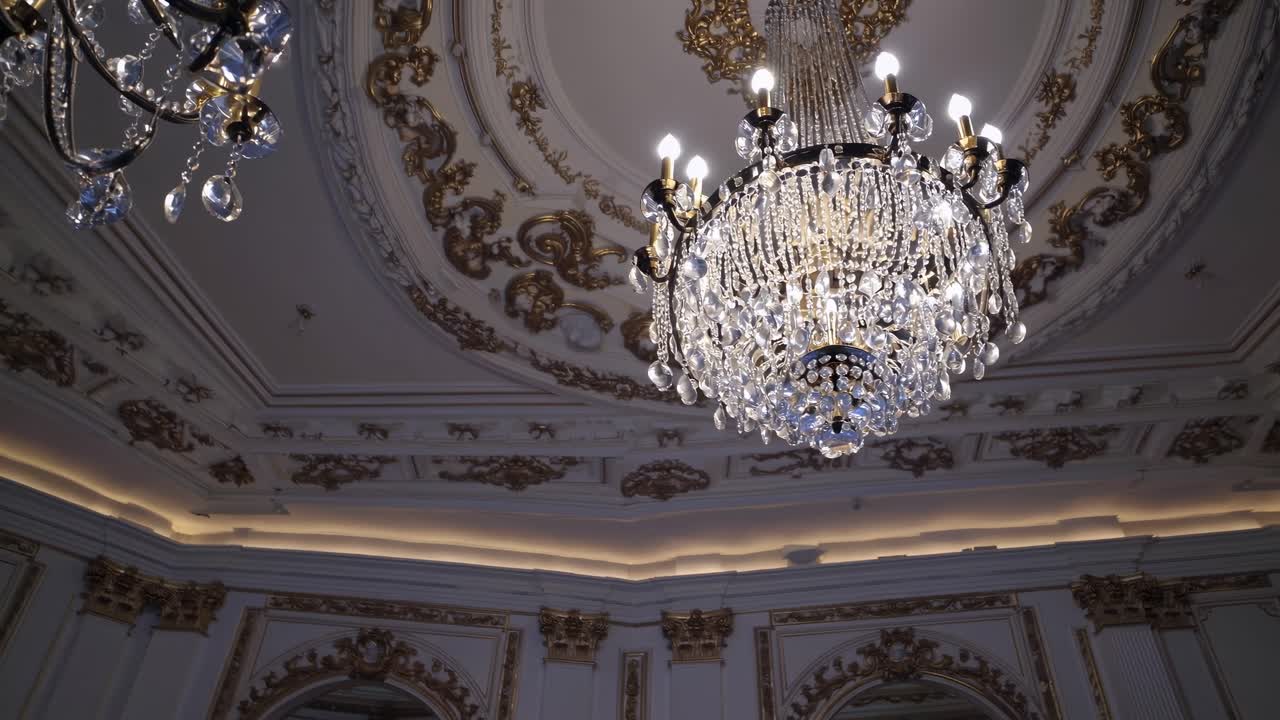 Elegant video scene of a grand chandelier in a lavish room, captured from a low angle