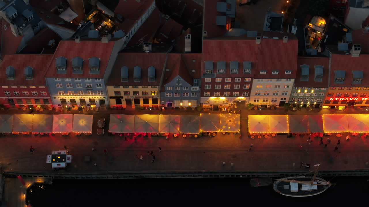 Aerial drone view of the Nyhavn waterfront, canal and entertainment district in Copenhagen, Denmark in the evening