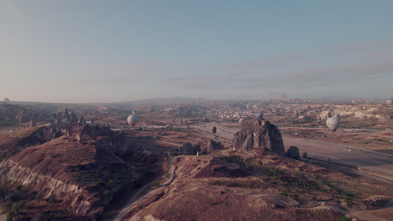 Cappadocia's rocky formations and hot air balloons at sunrise