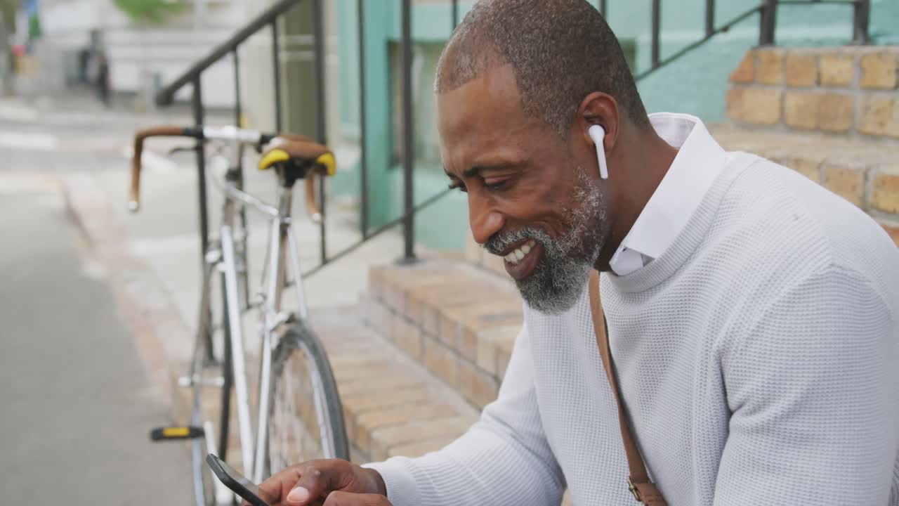 hombre afroamericano usando su teléfono en la calle