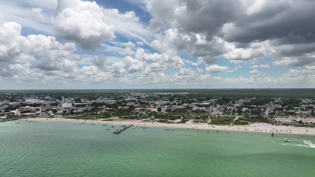 Panoramic aerial view of Progreso, Yucatán, on a bright day with large cloud formations over the coast. Drone flyin forward