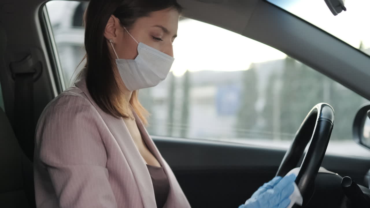 mujer conduciendo en un coche con máscara y guantes durante la pandemia