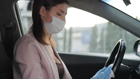 woman driving in a car with mask and gloves during pandemic
