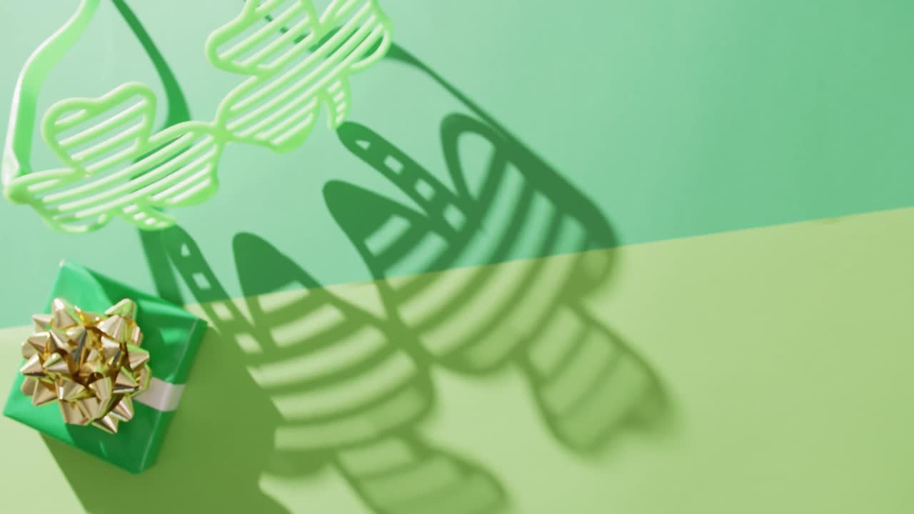 Video of st patrick's green shamrock glasses and present with copy space on green background