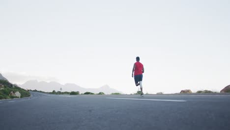 African-american-man-wearing-sportswear-running-on-the-road