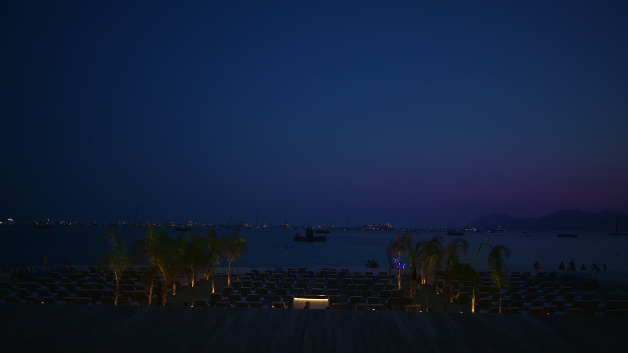View of multiple, empty loungers on the beach at night in Cannes, France