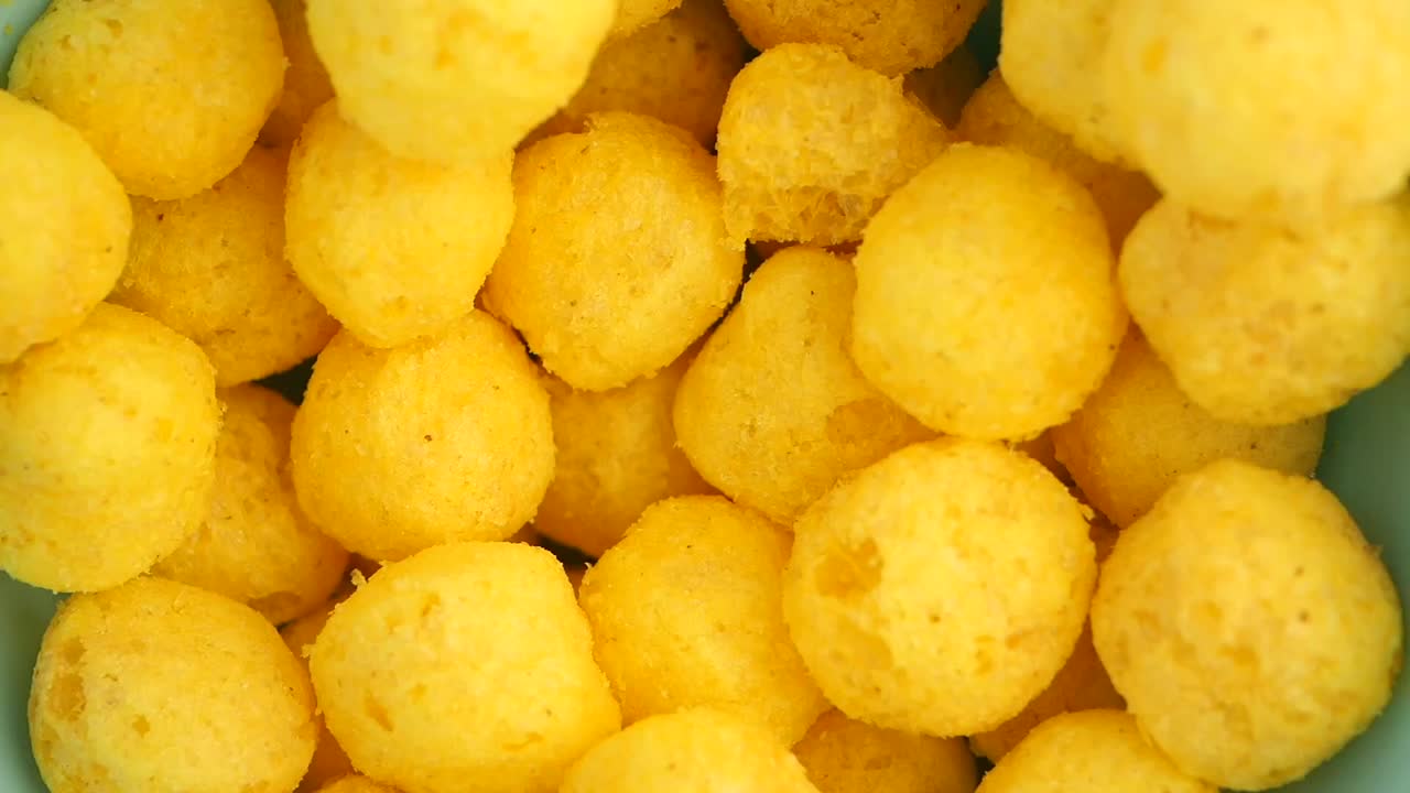 Close-up of Yellow Puffed Snacks (Cheese Balls/Puffs)