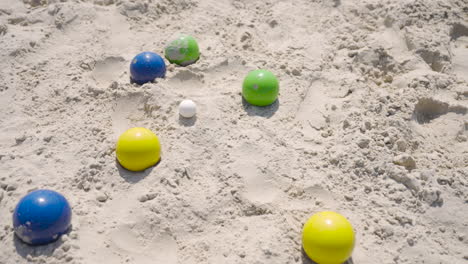 Blick-Von-Oben-Auf-Einige-Bunte-Pétanque-Kugeln-Am-Strand-An-Einem-Sonnigen-Tag