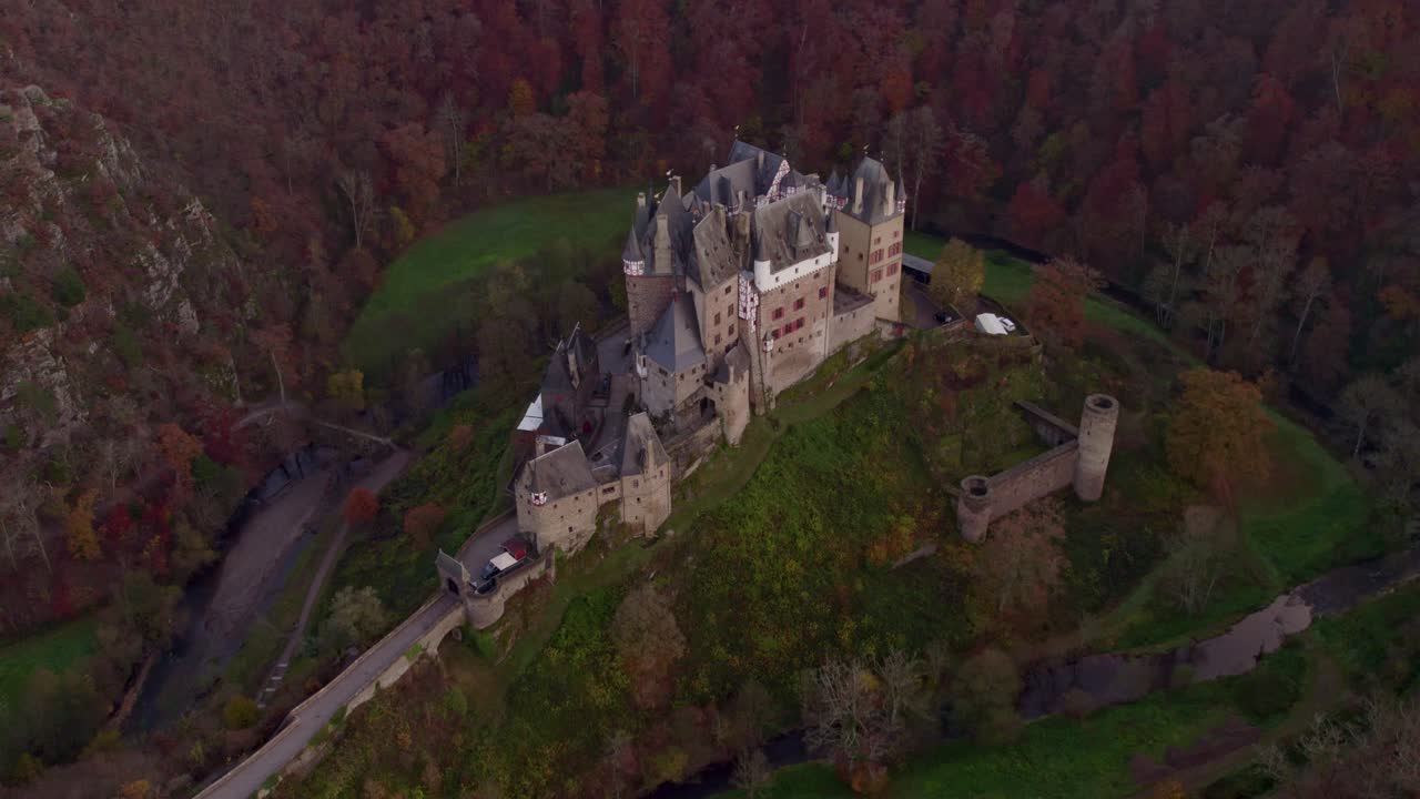 Il tramonto illumina il Castello di Eltz in un paesaggio boscoso, Germania