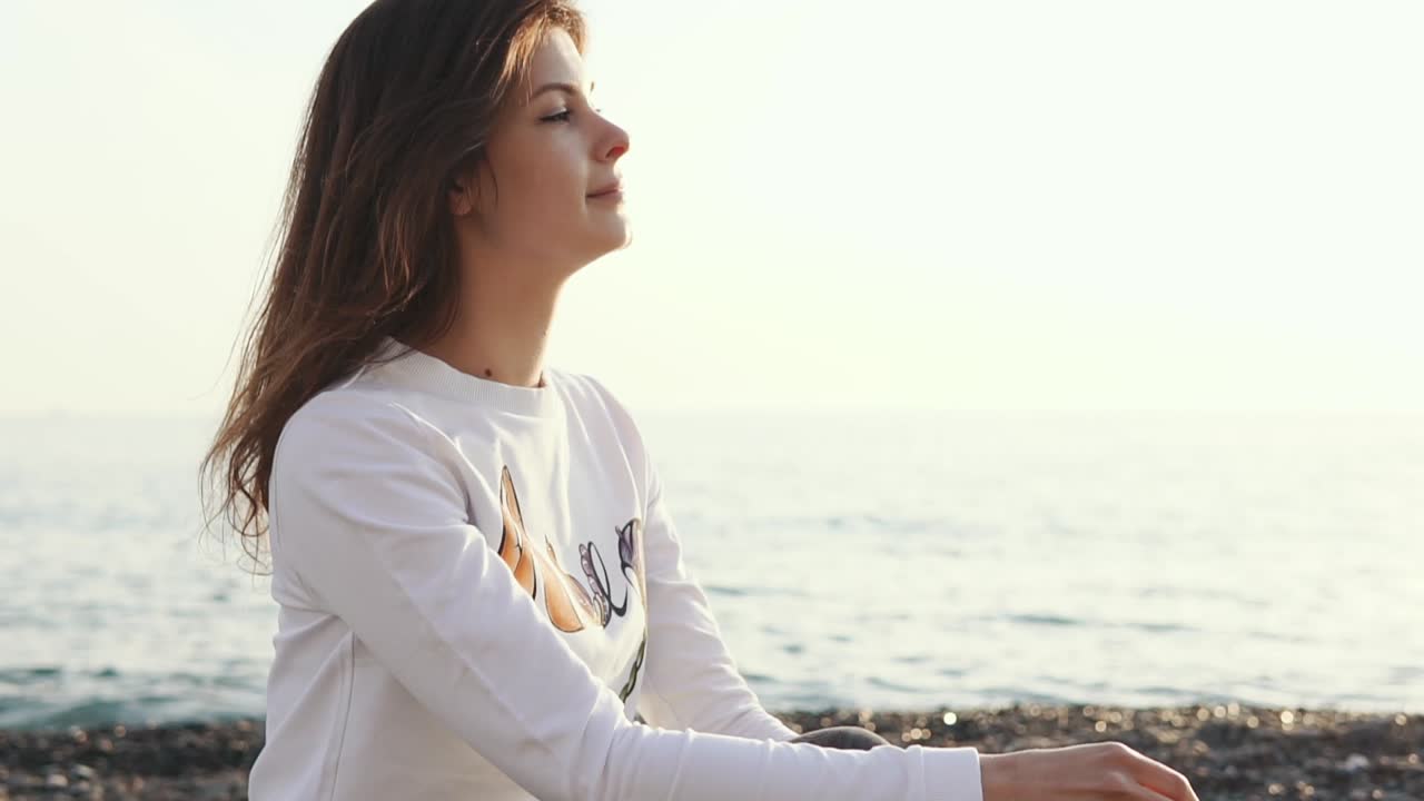mujer relajándose en la playa al atardecer