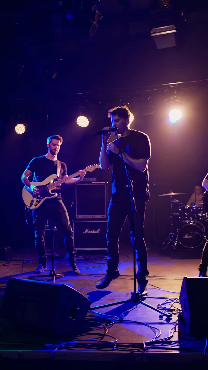 Low-angle shot of a rock band performing on stage with dramatic lighting, capturing a dynamic live