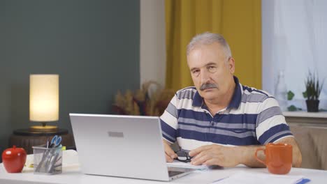 home office worker old man looking dull at camera.