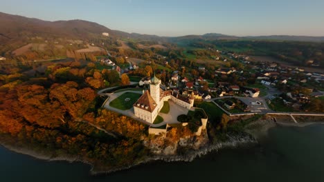 fpv approaching stunning schönbühel castle, diving down past it, showing the beautiful danube river during autumn sunset