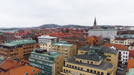 colorful living apartment buildings and church tower of borås town, aerial fly forward view