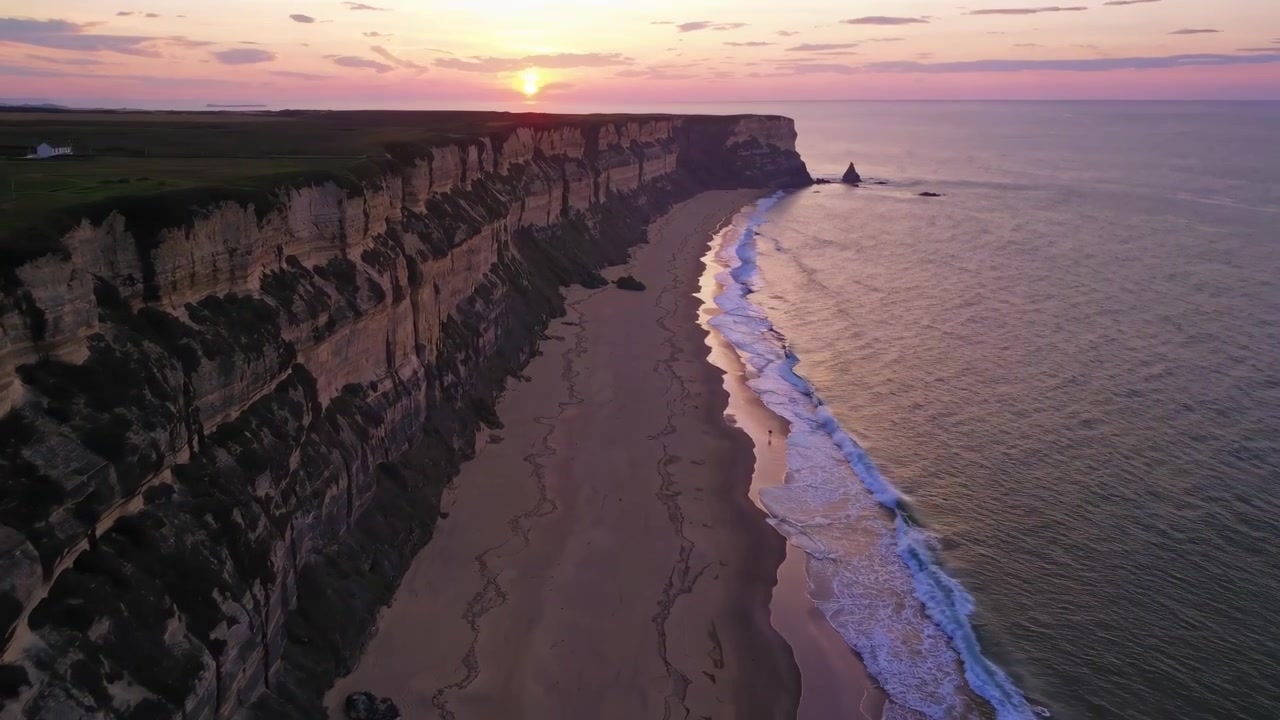 Luftaufnahme dramatischer Küstenklippen bei Sonnenuntergang