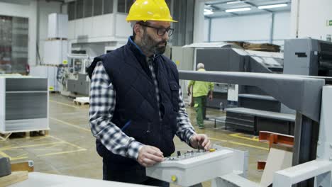 focused mature male worker setting machine