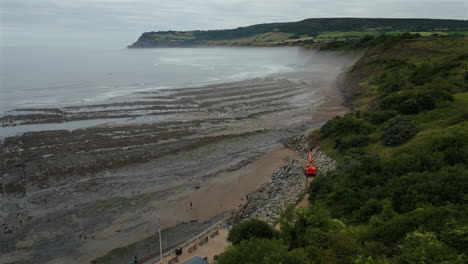 Establecimiento-De-Una-Toma-Aérea-De-Un-Dron-De-La-Brumosa-Costa-Norte-De-Yorkshire-Cerca-De-La-Bahía-De-Robin-Hood-Durante-La-Marea-Baja.