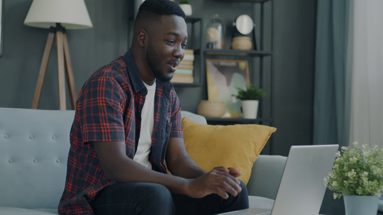 hombre usando computadora portátil en el sofá