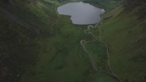 aerial 4k tilt shot of mountain stream and lake