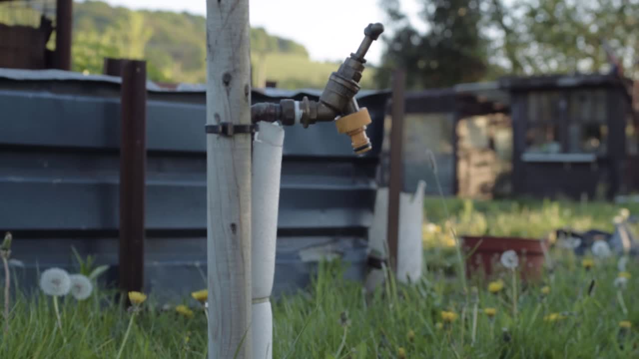 Faucet tap in garden wide panning shot