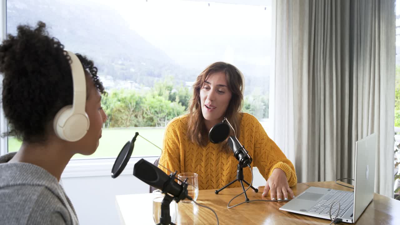 Diverse co-conduttrici che salutano, parlano al microfono, cliccano sul trackpad in un podcast casalingo, con spazio per il testo.