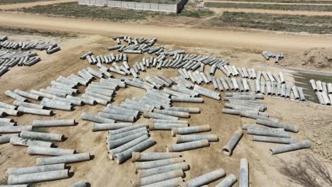 Aerial-View-Of-Concrete-Pipes-Drying-On-Ground-At-Construction-Site-In-Pakistan