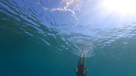 a young girl swims at the surface and