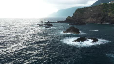 one man standing alone on top of the cliffs next to sexial natural pools in madeira