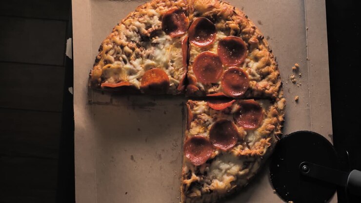 Pizza ai peperoni in stile italiano, mentre si prende una fetta
