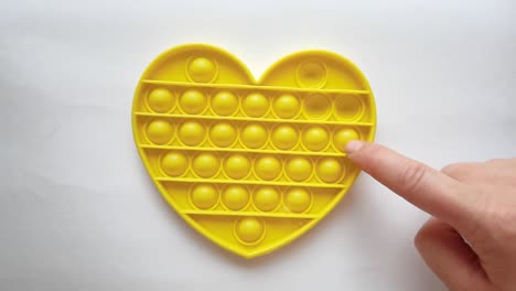 new baby toy. pop it finger play. funny color. adult hand squeeze round silicone. change form. yellow heart shape